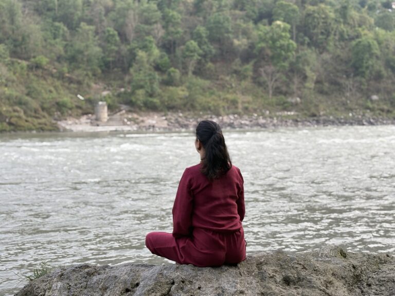 Sunrise over the Ganga river with a meditating seeker.